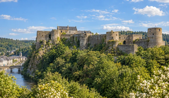 Vue illustrée du château de Bouillon dominant un paysage boisé